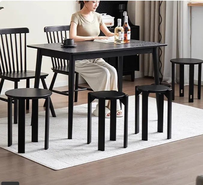Stackable round iron dining stool in a modern style, shown in a choice of smoked black, walnut, cherrywood, or cream colour.