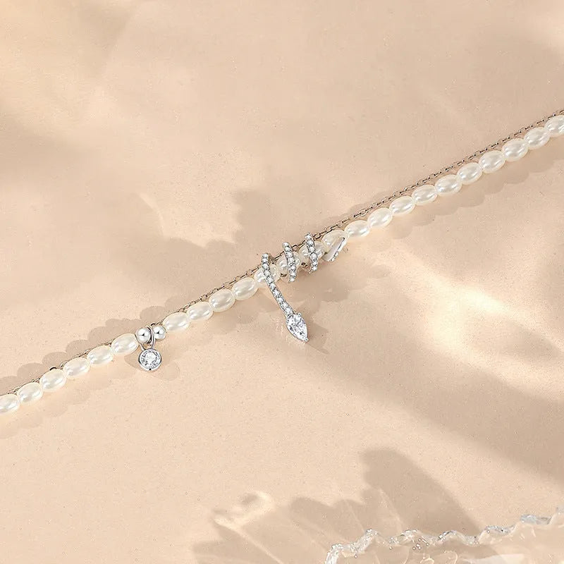 Close-up of a women's silver bracelet with a detailed pearl snake design, shown in both gold and white gold colour options.