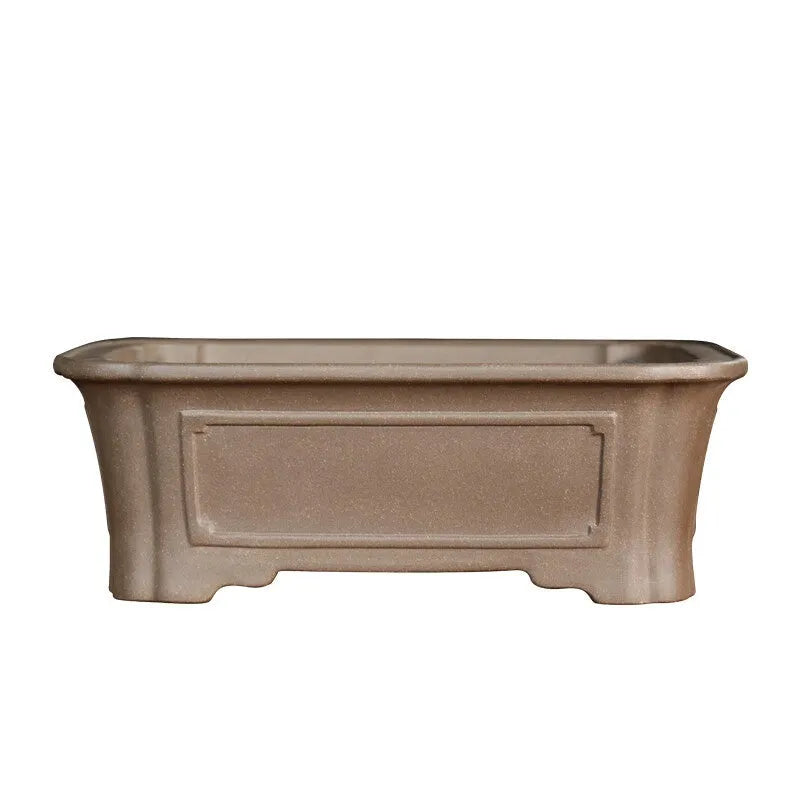 Antique rectangular purple sand bonsai pot with manger design on a floor.