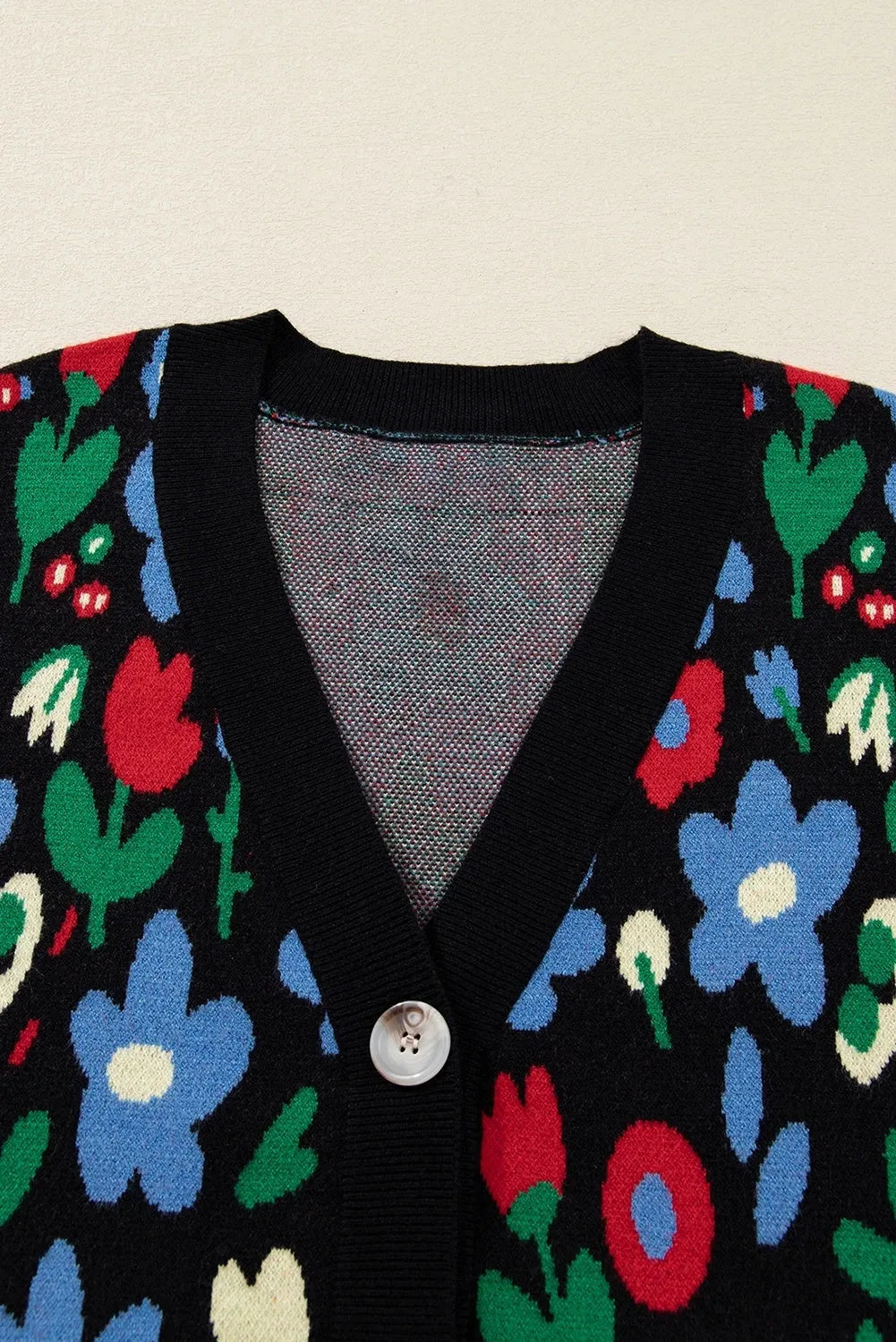 Black floral print V-neck button short cardigan sweater on model, long sleeves, shift silhouette
