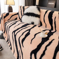 Zebra pattern thickened flannel sofa cover in caramel colour with matching pillowcase on a grey sofa.
