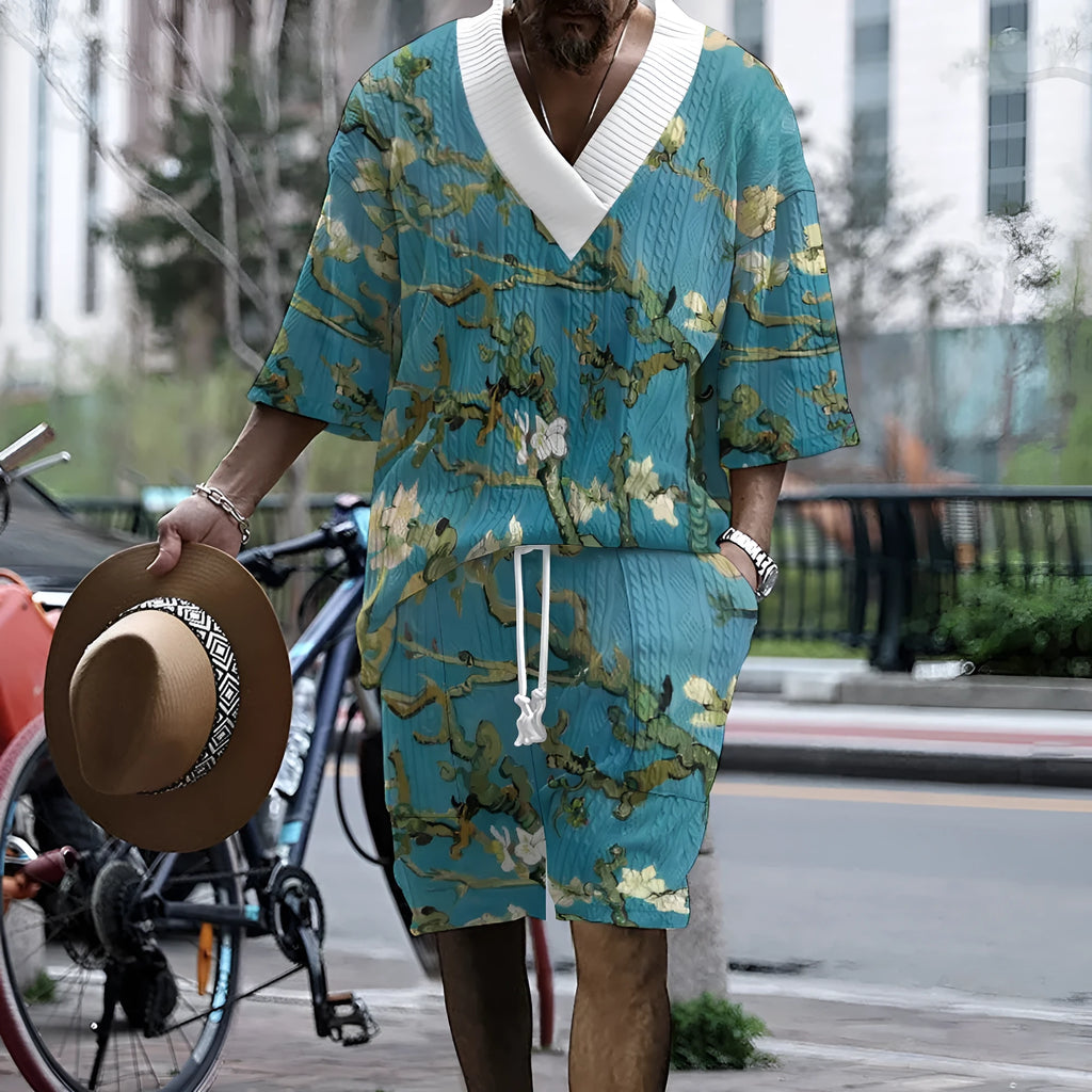 Men's peacock blue knitted casual shorts suit with T-shirt top on a plain background.