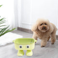 Green robot-shaped elevated cat bowl with tilted food surface and non-slip base