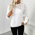 White women's long sleeve top with floral pattern, loose fit, on a hanger.