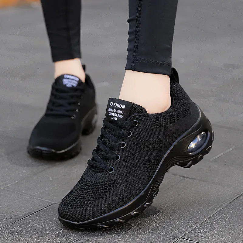 Women's low-top black mesh sneakers with white laces and a 3-5cm heel on a grey background.