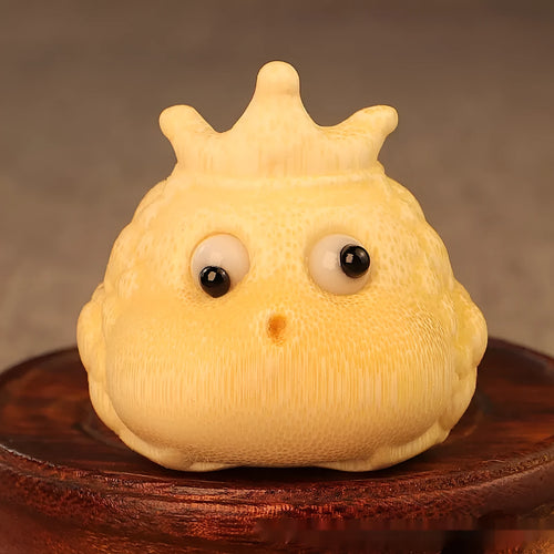 Solid bamboo carving of a cute Crown Princess toad ornament on a wooden surface.