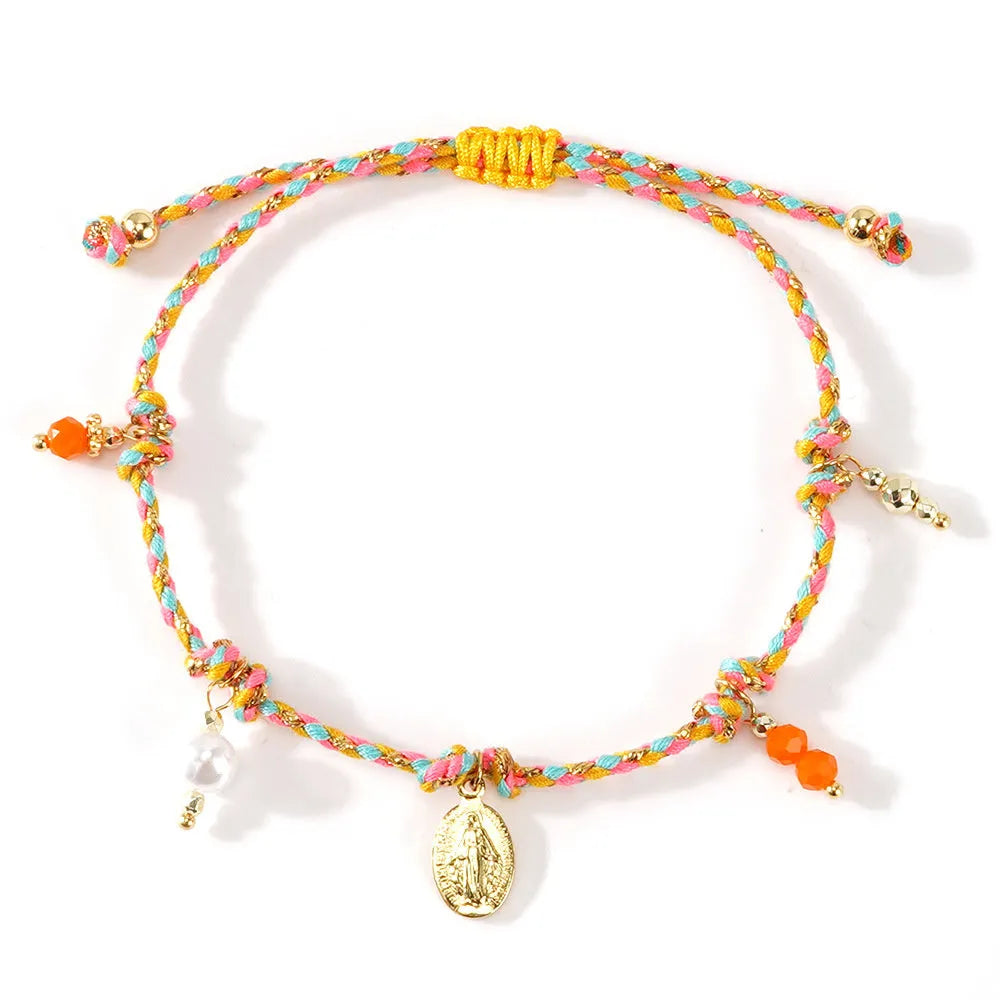 Close-up of a colourful hand-woven adjustable bracelet with an ethnic-style strap tag on a wrist.