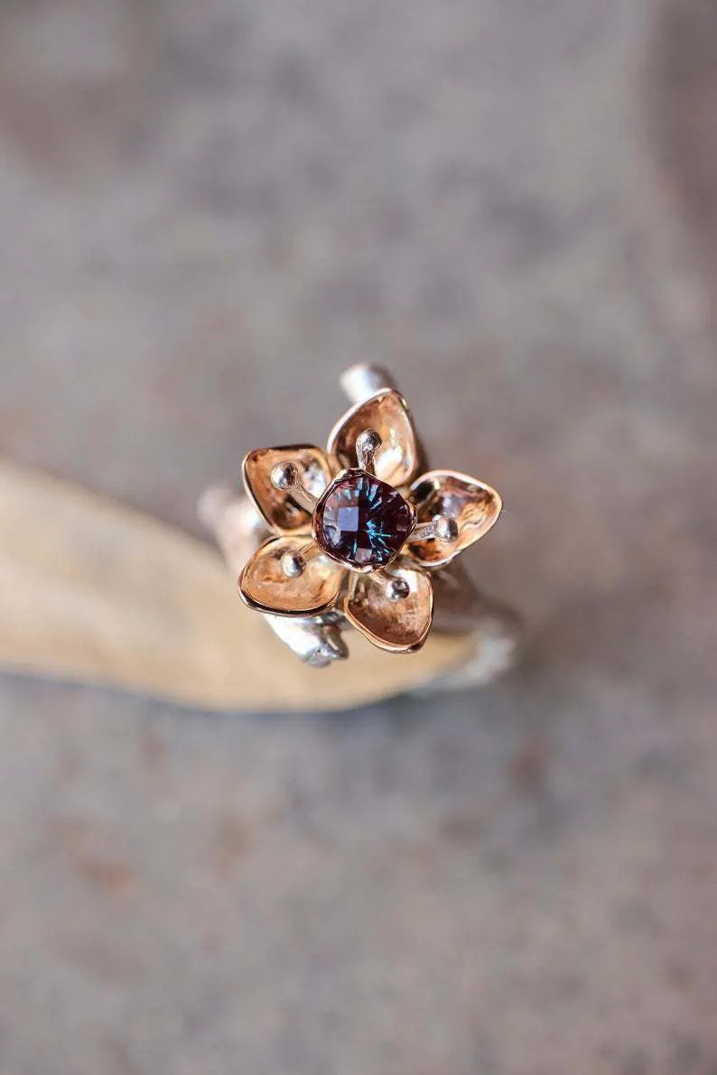 Geometric silver two-tone women's ring with open floral detail on a plain background.
