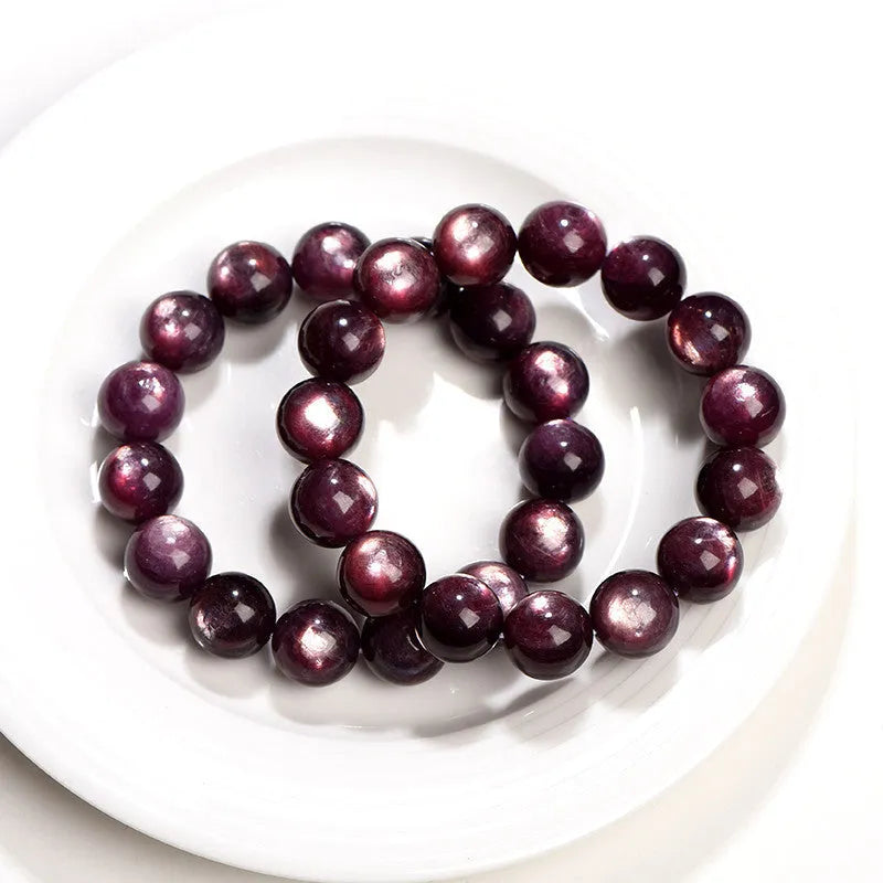 Natural purple lepidolite crystal bracelet with polished round beads on a white background.