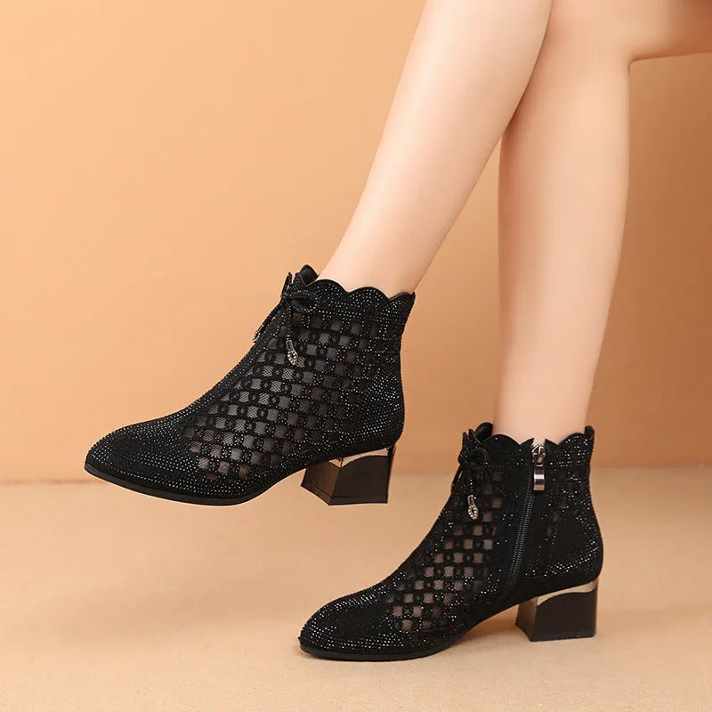 Black women's ankle boots with cutout mesh panels, mid heel, side zipper, and rhinestone sequin details