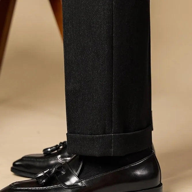 Men's black genuine leather tassel loafers with a polished finish and rubber sole.