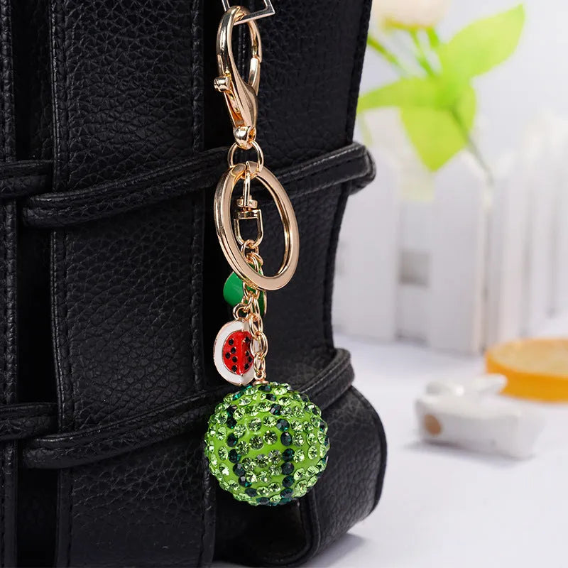 Green zinc alloy watermelon-shaped keychain with diamond design, measuring 12cm.