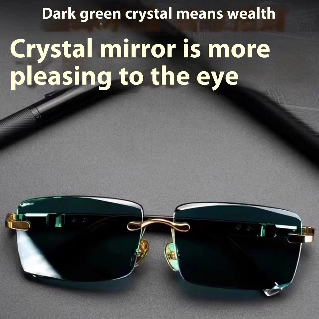 Frameless dark green crystal lens sunglasses with adjustable nose pads on a table next to their hard case.