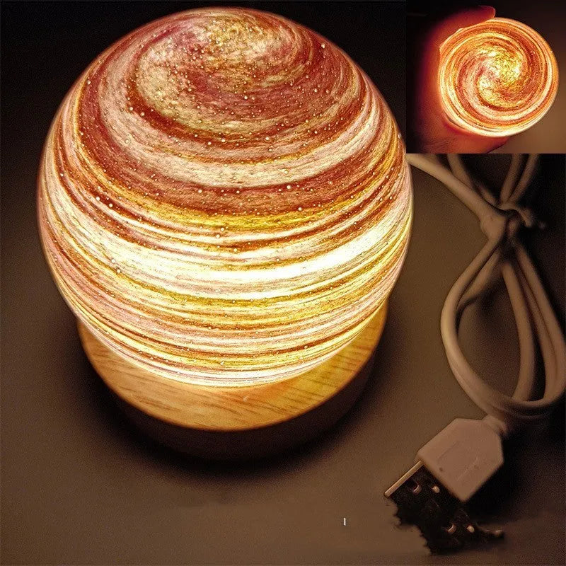 Modern planet-shaped USB night light on its base with dimmable multi-colour glow