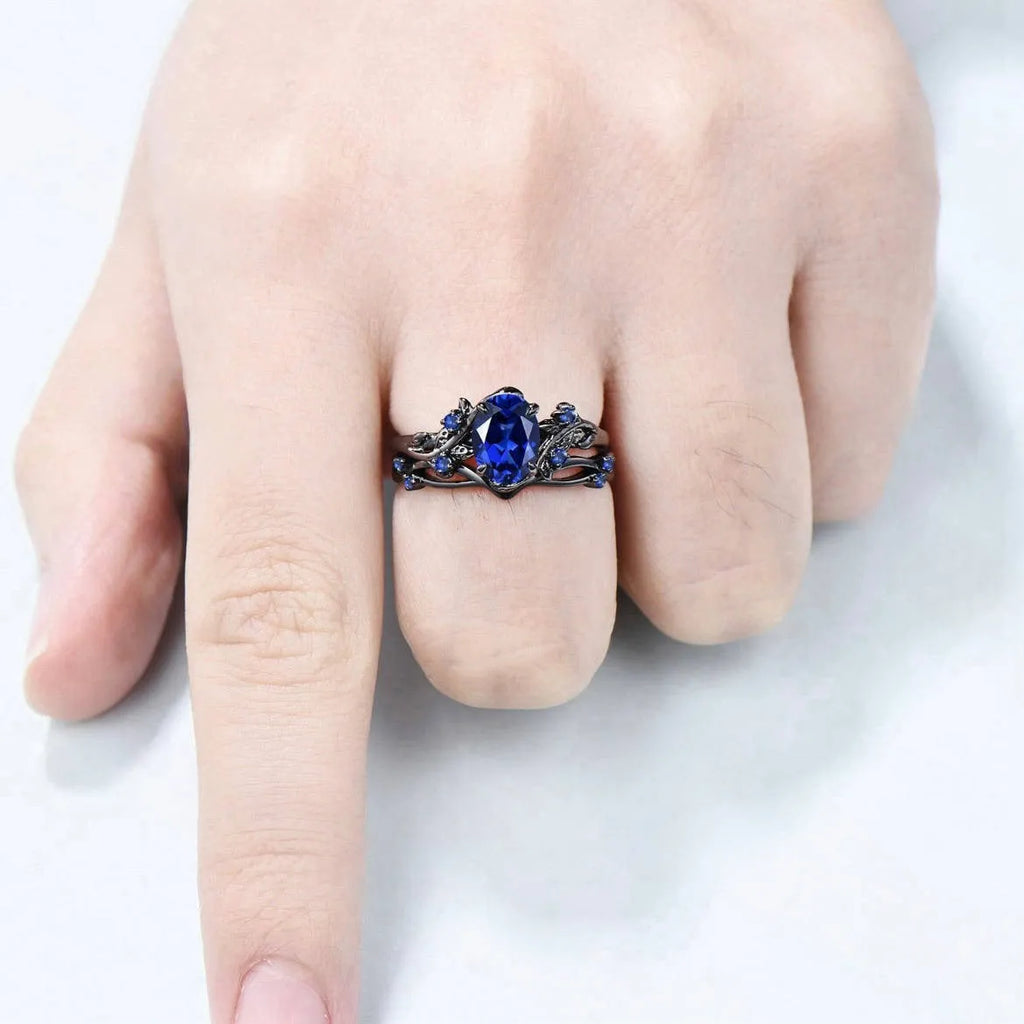 Geometric gun black couple ring for women with a single inlaid navy blue rhinestone.