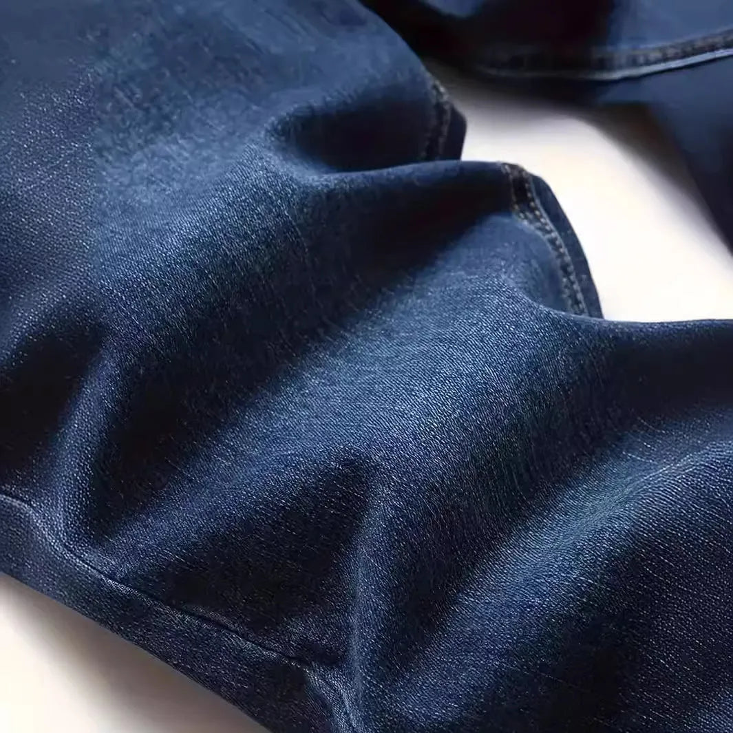 Men's dark blue slim fit skinny jeans on a hanger, showing mid waist and zipper fly detail.