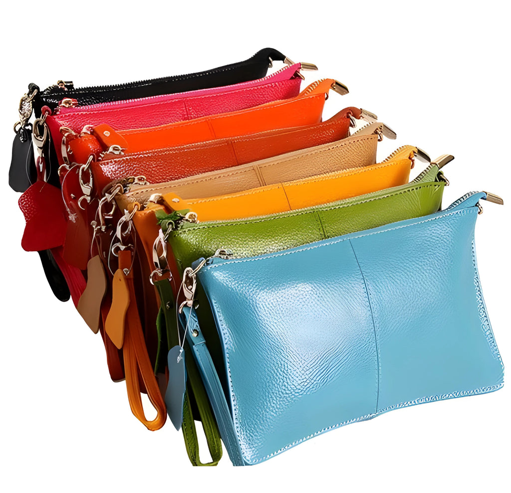 A small lady's cowhide slant handbag in claret colour, showing the hand strap and long shoulder strap.