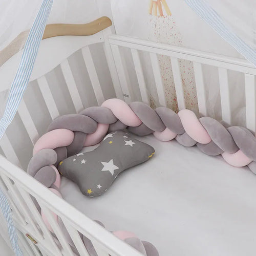 Braided knot pillow cushion bumper for infant crib in spandex velvet, shown in a light colour.