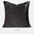Modern gray and white plaid bed runner blanket with matching pillowcase and round leather-look pillow on a bed.