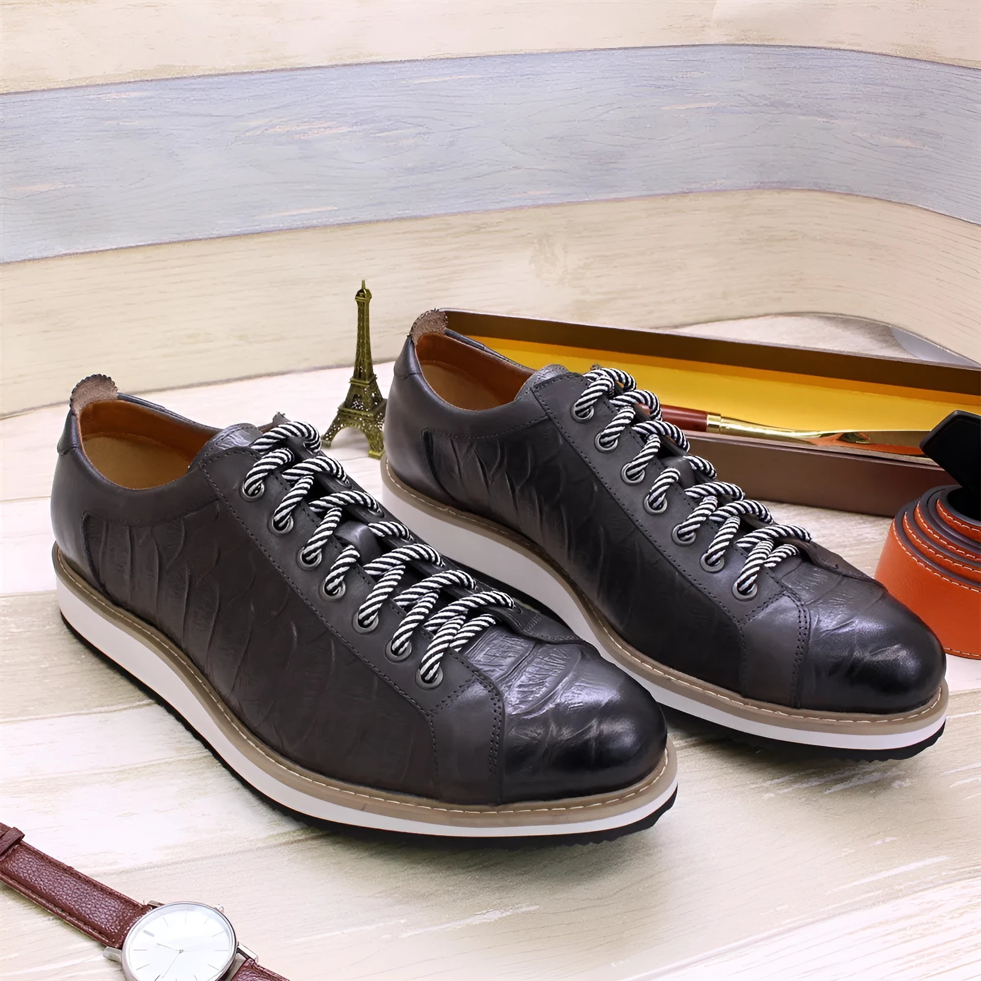 Men's low-top handmade shoes with embossed pattern on upper, shown in black with front tie laces.
