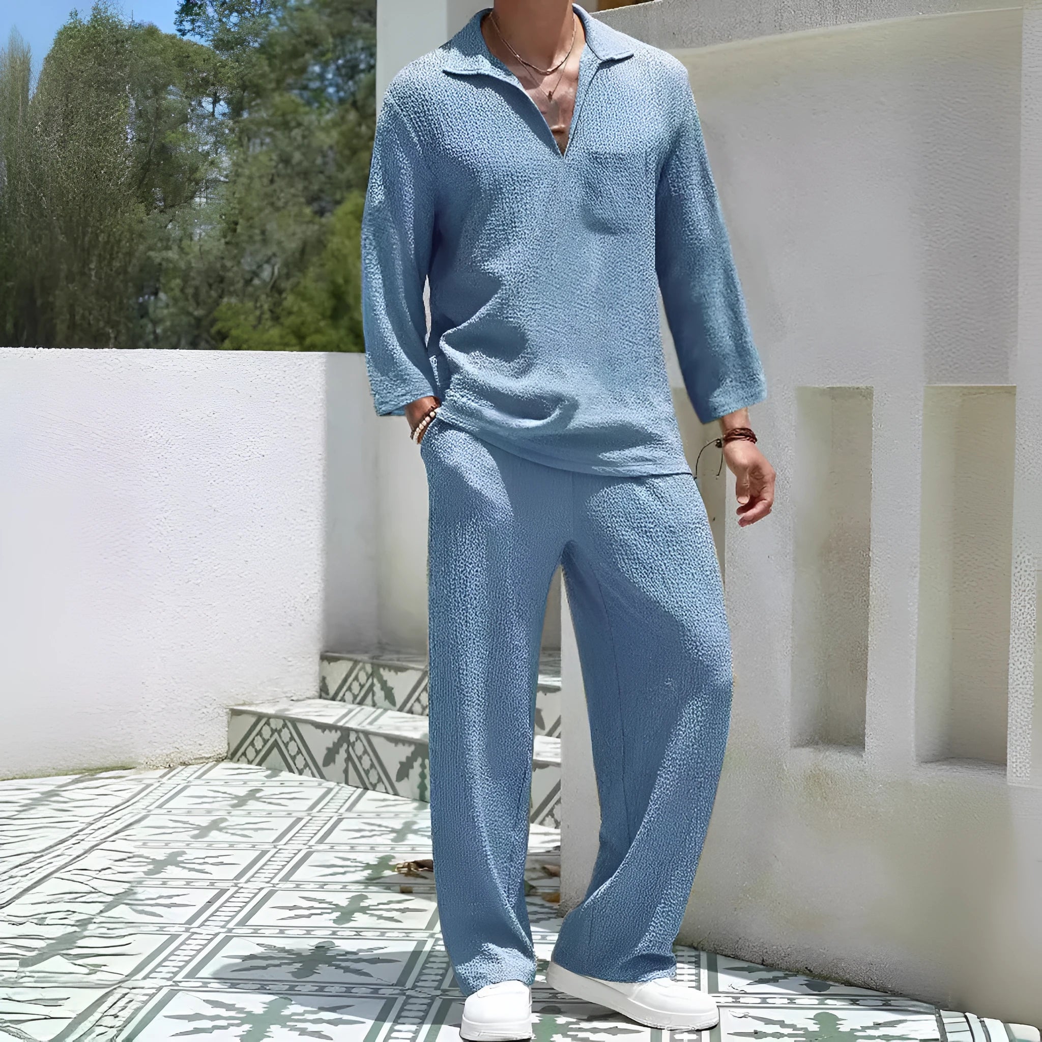 Man wearing a casual lake blue polyester shirt and matching trousers from a two-piece suit set.