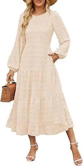 A woman wearing a beige high waist long sleeve dress with ruffled sleeves, a round neck, and a solid colour design.