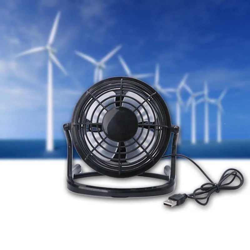 Compact black mini USB desk fan with adjustable tilt head on a wooden desk.