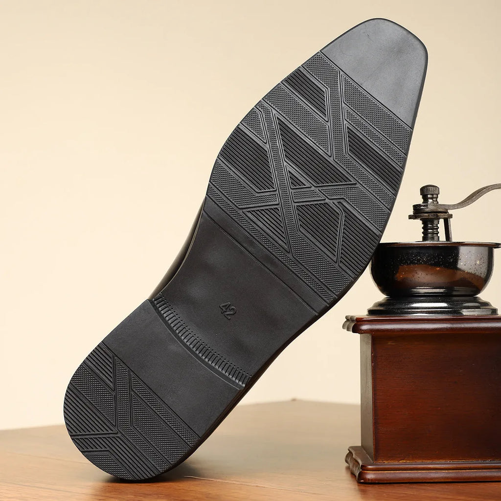 Men's brown formal shoes with side zipper, square toe, and low rubber sole on a neutral background