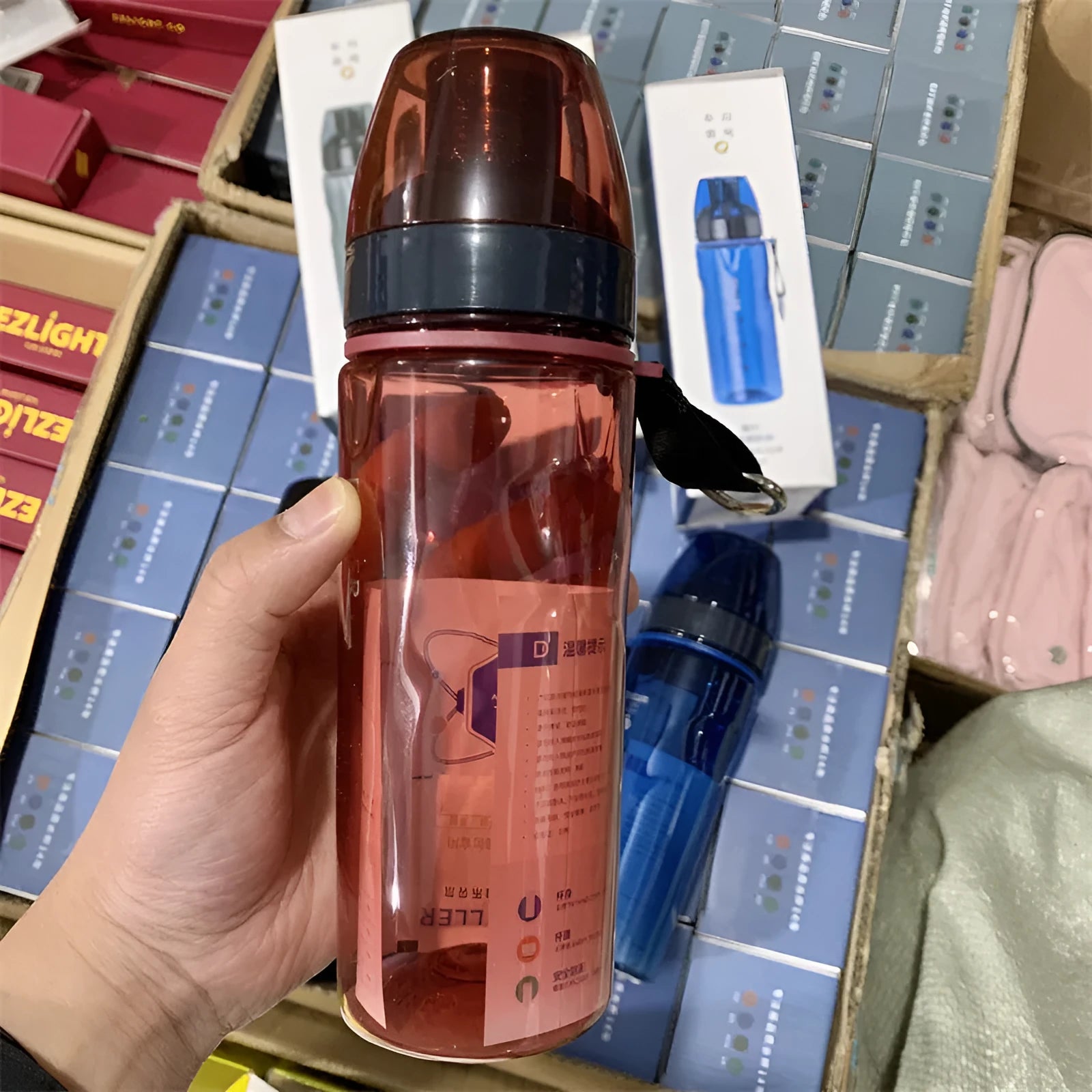 Chinese-style blue portable sports water bottle with integrated tea compartment and removable filter on a grey background.