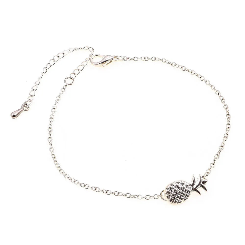 Gold tone alloy bracelet with a detailed pineapple charm on a simple bangle.