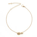 Gold tone alloy bracelet with a detailed pineapple charm on a simple bangle.