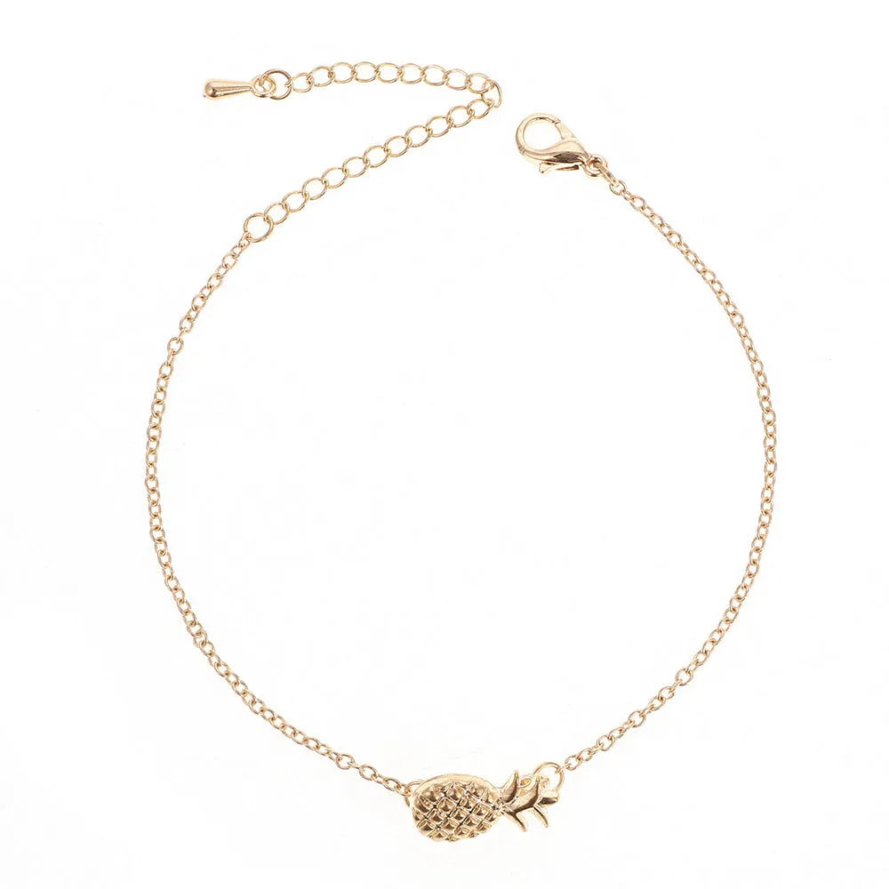 Gold tone alloy bracelet with a detailed pineapple charm on a simple bangle.