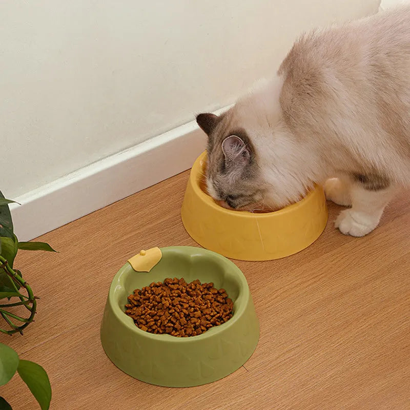 Green plastic double pet bowl for cats and small dogs on a floor.