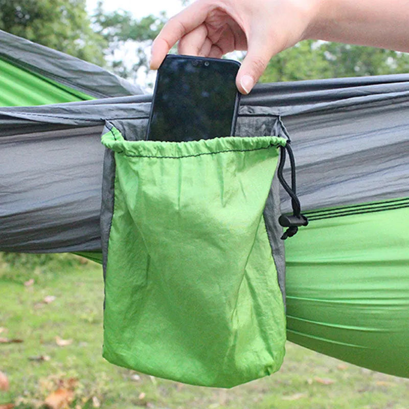 Blue nylon parachute camping hammock hung between two trees, showing its full 270cm length and 140cm width.