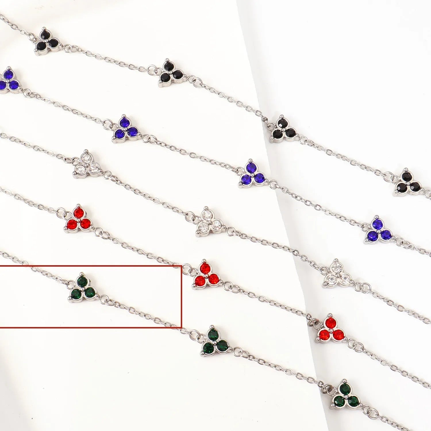 Geometric stainless steel women's bracelet with triangular links and a coloured stone centre.