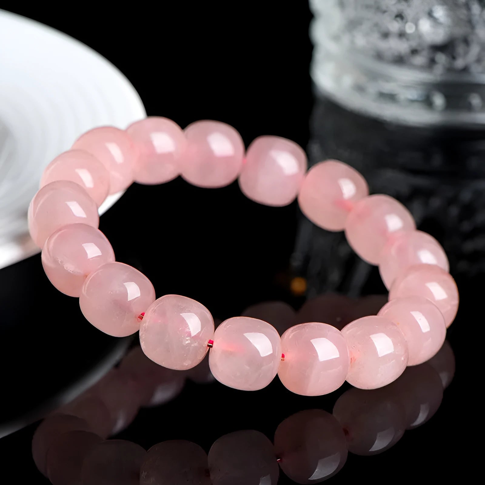 Pink natural crystal bracelet with 8x10mm barrel-shaped beads on a cord.
