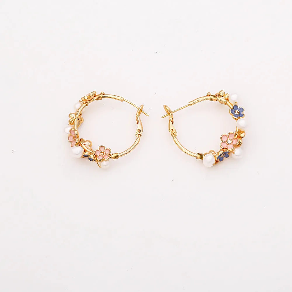 Natural freshwater pearl flower earrings with gold-plated copper setting, pair of earrings on display