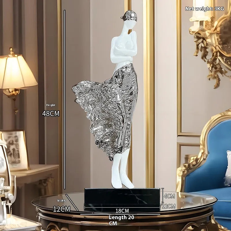 Tall modern sculptured character ornament in a metallic rose gold finish on a table.