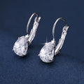 A pair of simple drop-shaped copper earrings with a platinum gem setting, shown in gold colour.