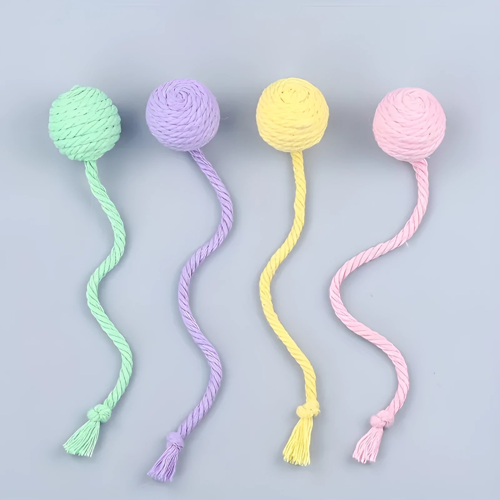Cat toy ball with rope attachment and bell inside, shown in green, pink, purple, and yellow colour options