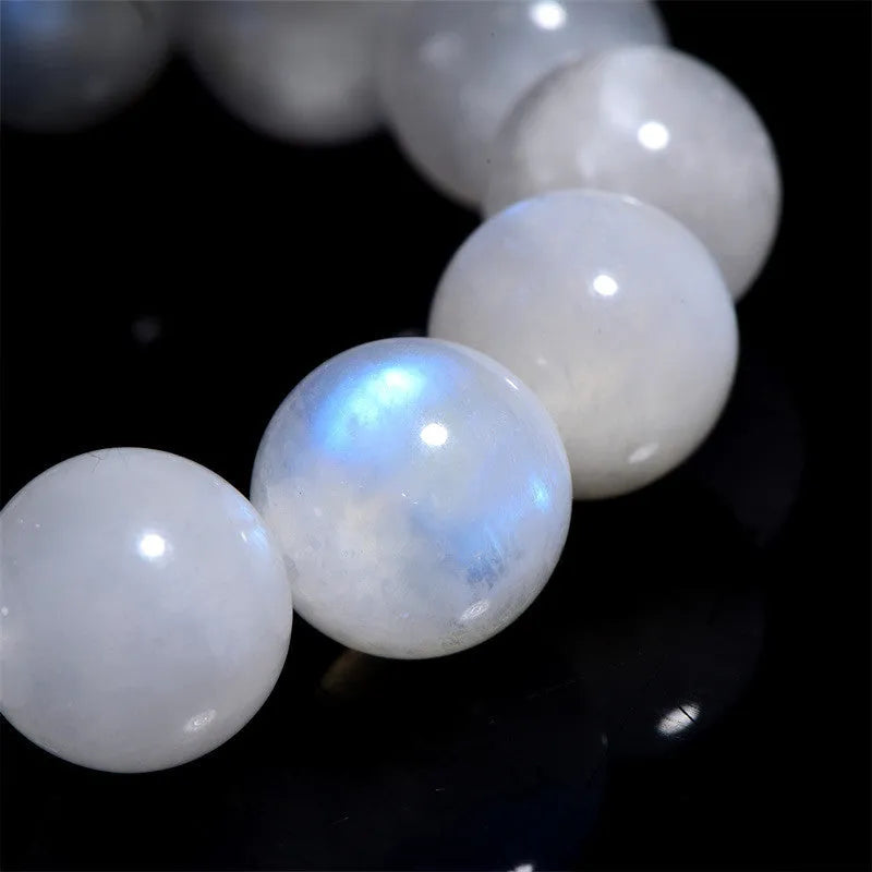Natural blue moonlight round moonstone bead bracelet on a wrist, showing adjustable closure.