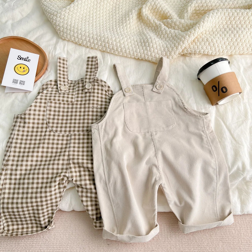 Unisex corduroy suspender overalls in creamy-white or brown plaid, with large pockets and double-breasted closure, for spring and autumn.