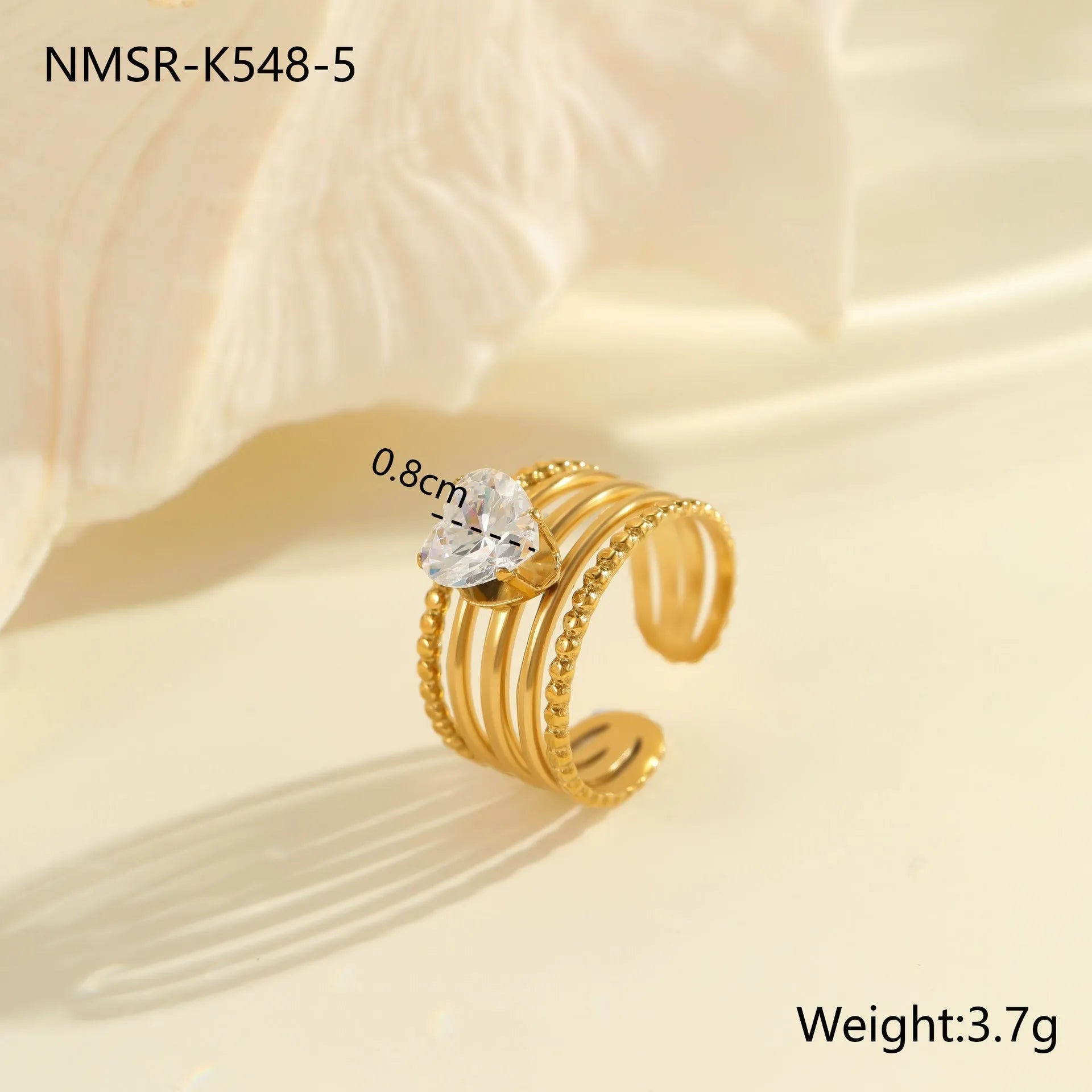 Geometric gold-coloured stainless steel ring with open mouth design on a plain background