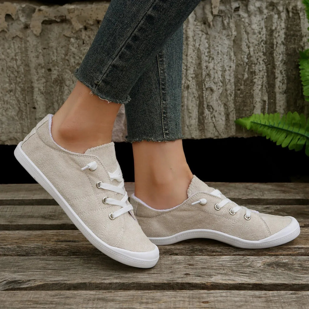 Women's beige low-top fabric casual sneakers with a rubber sole on a neutral background.