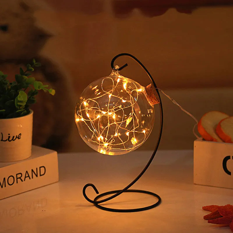 Round glass LED wishing bottle 12 cm with cork, 20 warm white lights, and folded star paper strips on a table