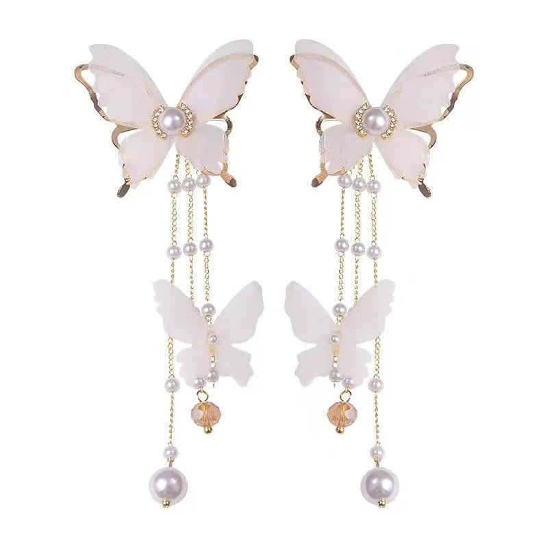 White butterfly tassel drop earrings with faux pearls and clear rhinestones on a copper alloy base.