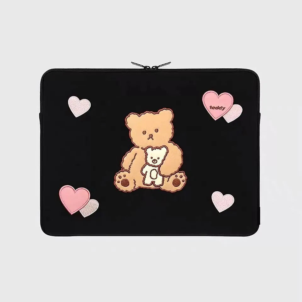 Embroidered animal design laptop sleeve in polyester, shown next to a laptop.