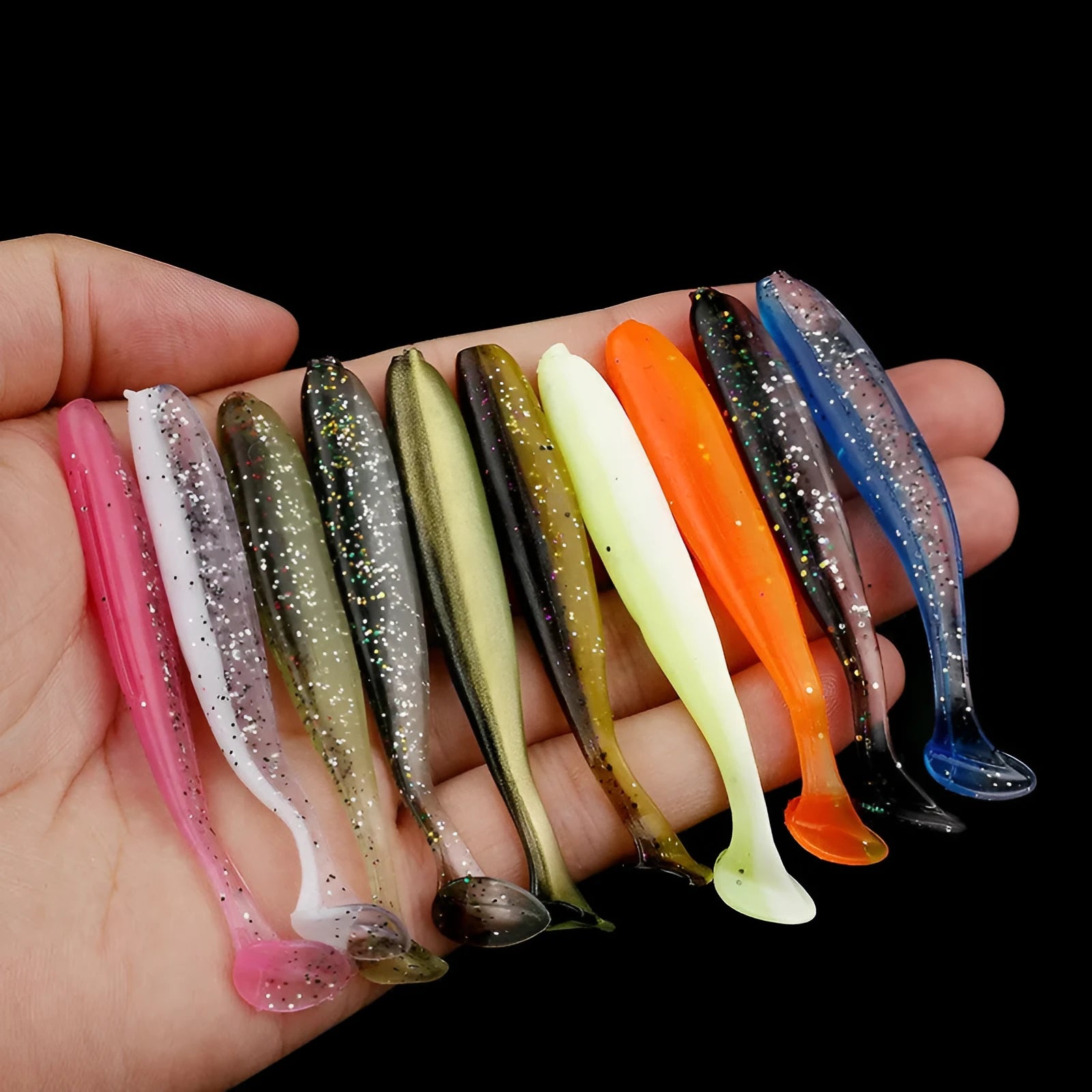 Close-up of a two-tone soft plastic T-tail worm fishing lure, 7cm long, on a hook.