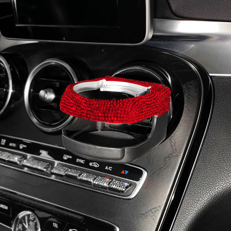 White diamond encrusted car cup holder bracket mounted on a vehicle air vent.