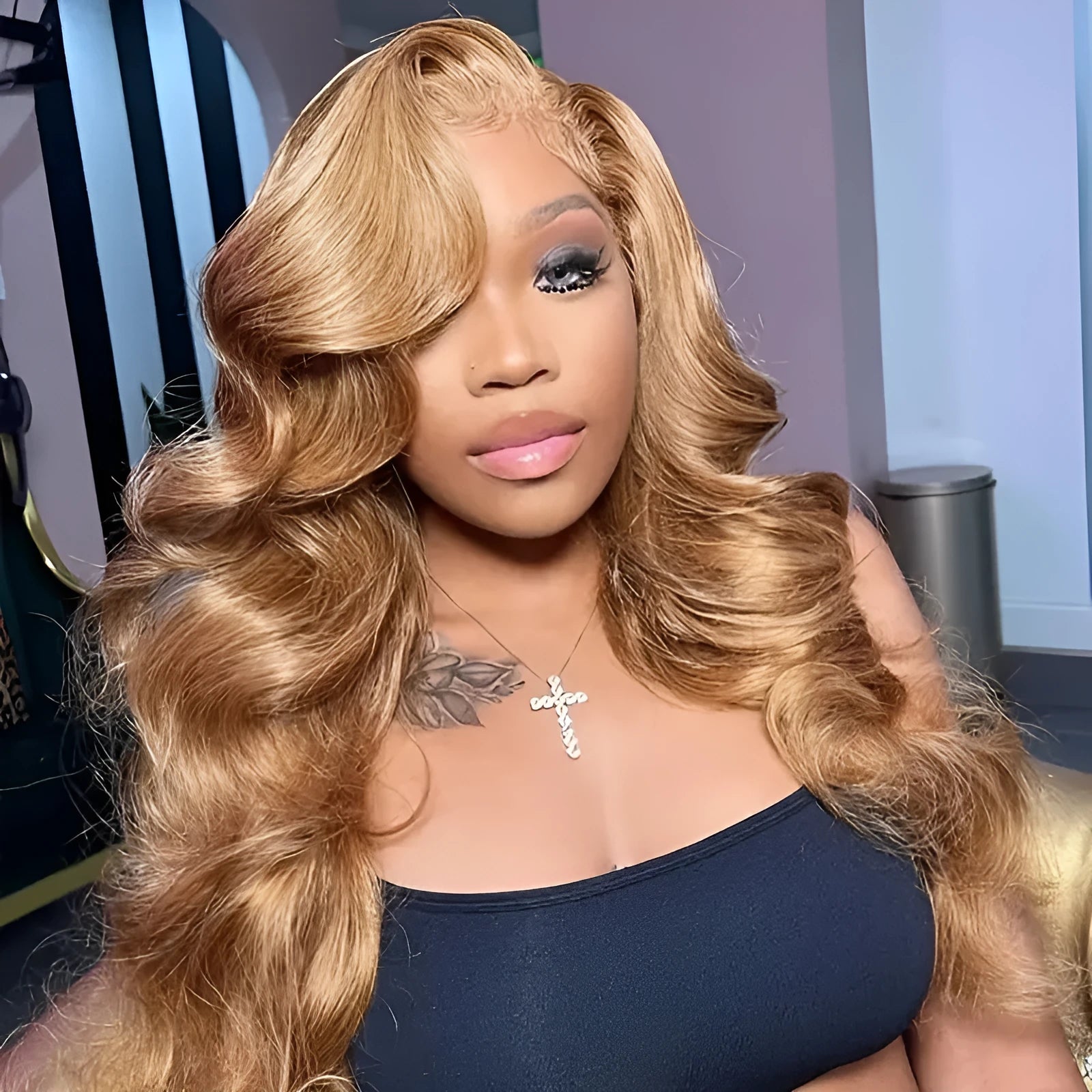 Long golden light brown synthetic wig with big curly waves and side bangs laid flat.